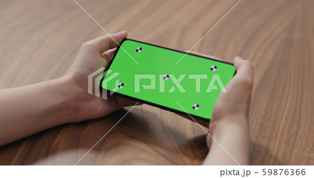 young woman holding smartphone over walnut table young woman holding smartphone over walnut table 59876366