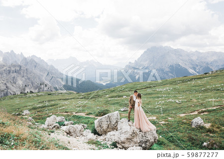 Just married couple kissing, mountains landscape on the background Just married couple kissing, mountains landscape on the background 59877277