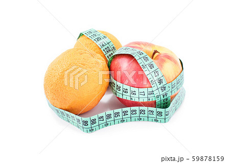 Measuring tape twisted around apples and oranges Measuring tape twisted around apples and oranges 59878159