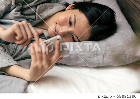 女性 スマホ ベッド 59881386
