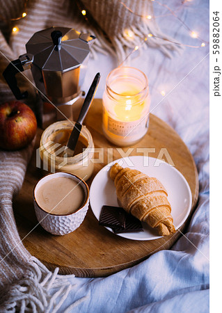 Cozy winter weekend breakfast, coffee and croissant on wooden tray Cozy winter weekend breakfast, coffee and croissant on wooden tray 59882064