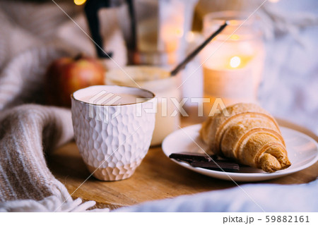 Cozy winter weekend breakfast, coffee and croissant on wooden tray Cozy winter weekend breakfast, coffee and croissant on wooden tray 59882161