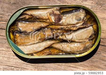Open tin can of sprats on rustic wooden table Open tin can of sprats on rustic wooden table 59882953