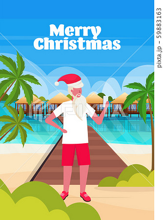man wearing santa claus hat using smartphone on tropical beach new year christmas vacation holiday 59883163