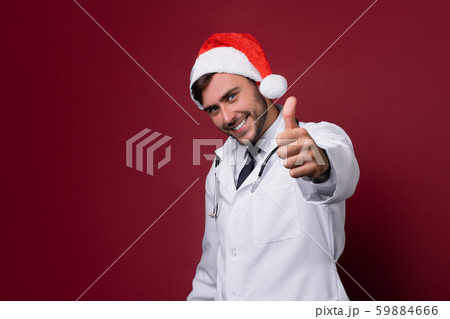 Young handsome doctor in white uniforme and Santa Young handsome doctor in white uniforme and Santa 59884666