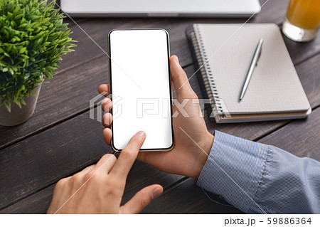 Unrecognizable man using smartphone with blank screen in cafe Unrecognizable man using smartphone with blank screen in cafe 59886364