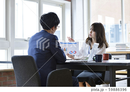 ビジネス イメージ 向かい合う男性に資料の説明をする女性 ビジネス イメージ 向かい合う男性に資料の説明をする女性 59886396