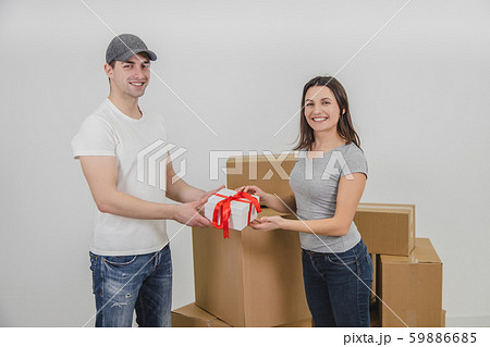 Courier delivered present for young woman who is moving into new apartment. Woman is really happy. Courier delivered present for young woman who is moving into new apartment. Woman is really happy. 59886685