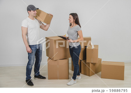 Lovely woman called in delivery man to transport all cardboard boxes into her new flat. 59886795