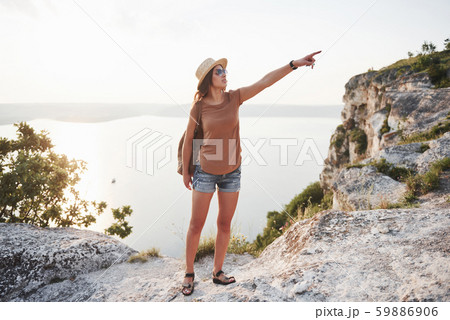 Young girl with backpack enjoying sunset on peak of rocky mountain. Travel lifestyle adventure Young girl with backpack enjoying sunset on peak of rocky mountain. Travel lifestyle adventure 59886906