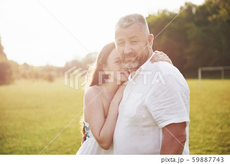 An elderly man hugged his adult daughter outdoors 59887743