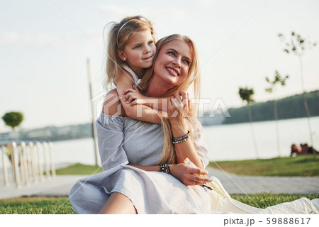 Happy young mother with a playful daughter in a park near the water 59888617