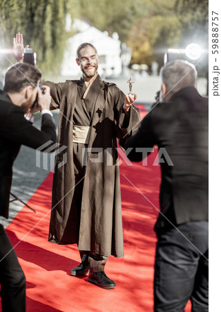 Film actor with photographers on the red carpet outdoors 59888757
