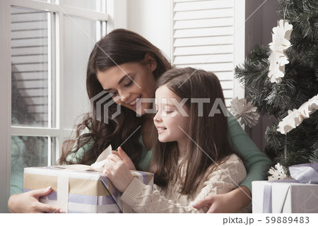 Mother and daughter unpack christmas gift Mother and daughter unpack christmas gift 59889483