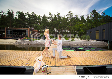 Young cute guy makes a marriage proposal to his 59890585