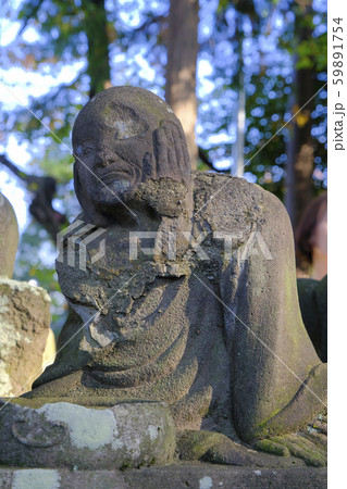 顔に手を当てる石仏（縦） 59891754