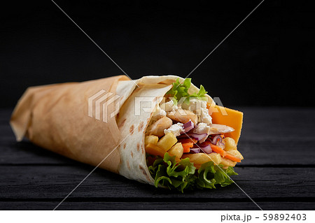 Tasty doner kebabs with fresh salad trimmings and shaved roasted meat served in tortilla wraps on 59892403