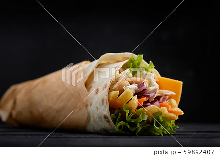 Tasty doner kebabs with fresh salad trimmings and shaved roasted meat served in tortilla wraps on 59892407