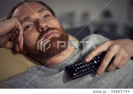 Sleepy Man Watching TV on Couch Sleepy Man Watching TV on Couch 59895744