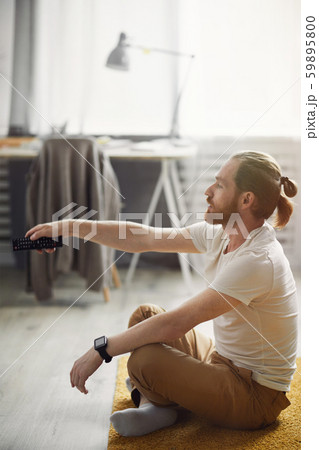 Contemporary Man Watching TV on Floor 59895800