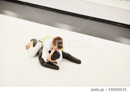 Boy fighting with mannequin in gym 59900035