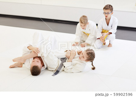 Boy fighting with girl at karate lesson Boy fighting with girl at karate lesson 59902596