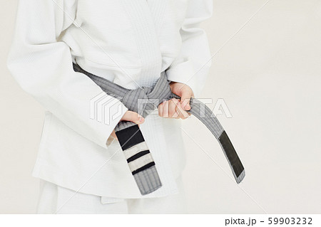 Young judoist getting a belt 59903232
