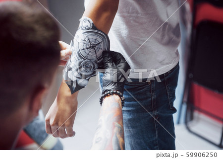 The tattoo artist sketches the drawing for his client 59906250