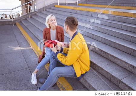 Cheerful couple relaxing on the empty stairs Cheerful couple relaxing on the empty stairs 59911435