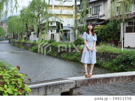 京都の町を散歩する黒髪ロングヘアの美少女大学生ポートレート 街歩きデートの写真素材