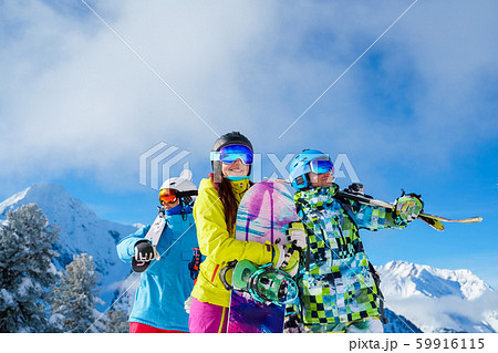 Men and woman with snowboard and skis looking in different directions standing on snow resort 59916115