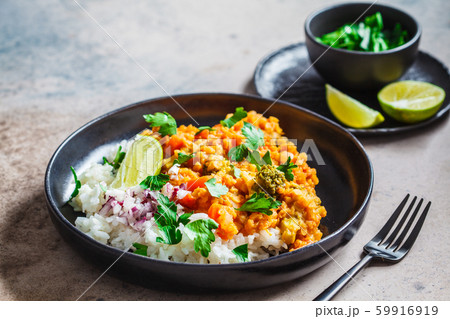 Vegetarian lentil curry with rice in black plate. Vegetarian lentil curry with rice in black plate. 59916919