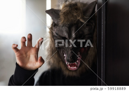 Model with scary wolf mask for Halloween party Model with scary wolf mask for Halloween party 59918889