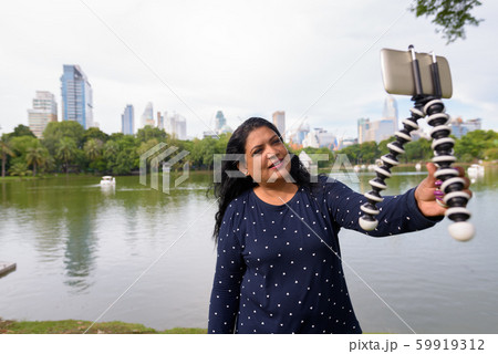 Portrait of mature Indian woman relaxing at the park 59919312