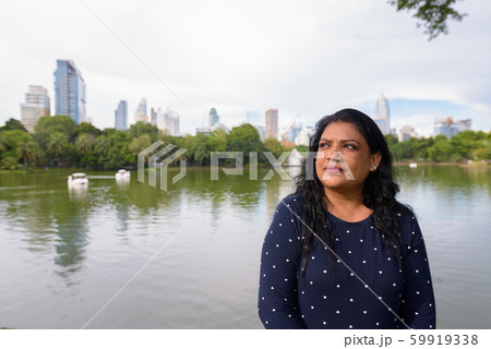 Portrait of mature Indian woman relaxing at the park Portrait of mature Indian woman relaxing at the park 59919338