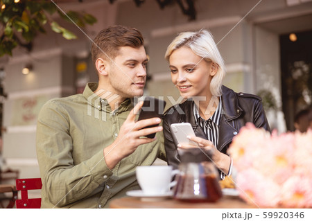 Couple discussing photos of their best friends 59920346