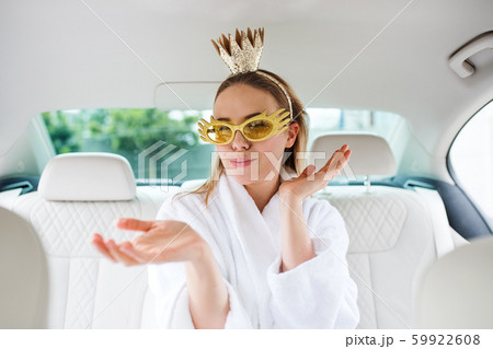 Young woman with party accessories sitting in car, having fun. Young woman with party accessories sitting in car, having fun. 59922608