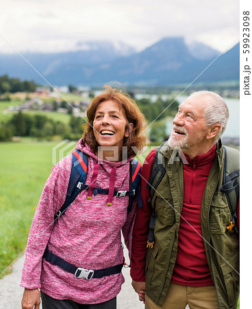 Front view of senior pensioner couple hiking in nature, talking. Front view of senior pensioner couple hiking in nature, talking. 59923098