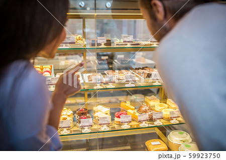 Businessmen looking at fridge with amazing desserts together 59923750