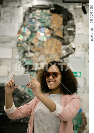 Happy young intercultural female tourist with smartphone making selfie 59924306