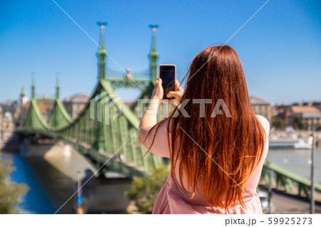 Young red-haired girl in a pink dress makes a Young red-haired girl in a pink dress makes a 59925273
