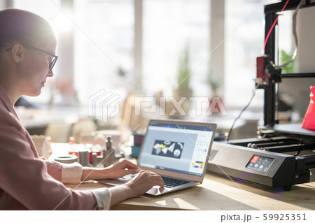 Creative female designer sitting by desk in office and making electronic sketch Creative female designer sitting by desk in office and making electronic sketch 59925351