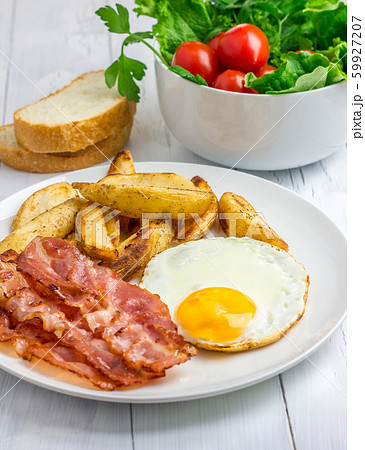 Hearty breakfast with bacon, fried egg, potato 59927207