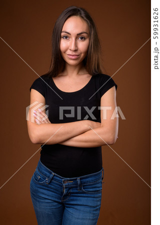 Studio shot of young beautiful woman against brown background 59931626