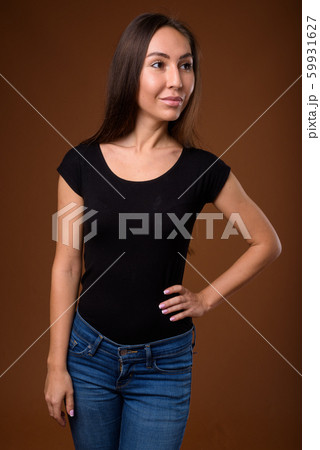 Studio shot of young beautiful woman against brown background 59931627