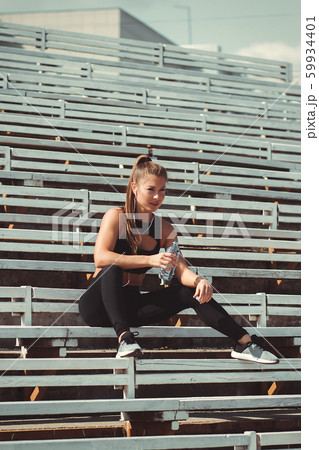 Tired woman in headphones resting and drinking 59934401