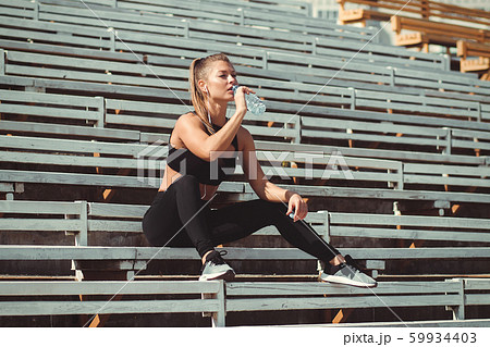 Tired woman in headphones resting and drinking 59934403