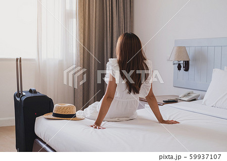 Young asian woman traveler with luggage sitting Young asian woman traveler with luggage sitting 59937107