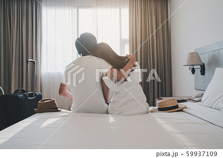 Young couple traveler with luggage sitting on bed Young couple traveler with luggage sitting on bed 59937109