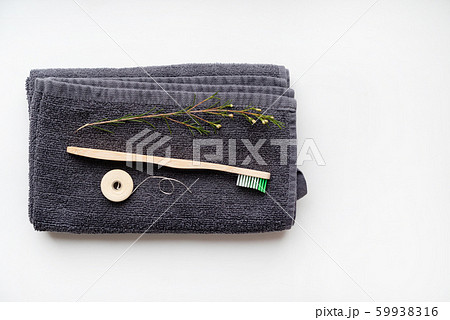 eco natural bamboo toothbrushes and biodegradable silk dental floss on the black towel, sustainable lifestyle concept. zero waste home. bathroom essentials, plastic free items eco natural bamboo toothbrushes and biodegradable silk dental floss on the black towel, sustainable lifestyle concept. zero waste home. bathroom essentials, plastic free items 59938316